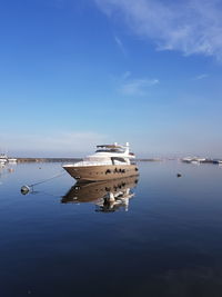 Ship moored on sea against blue sky