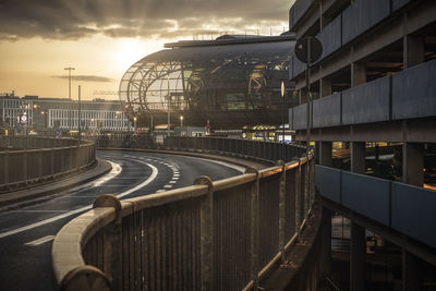 Railroad tracks amidst buildings in city during sunset