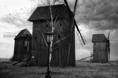 Old abandoned house on field against sky