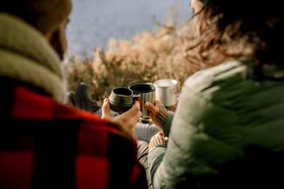 Friends toasting coffee during camping in forest