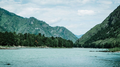 Scenic view of lake by mountains against sky