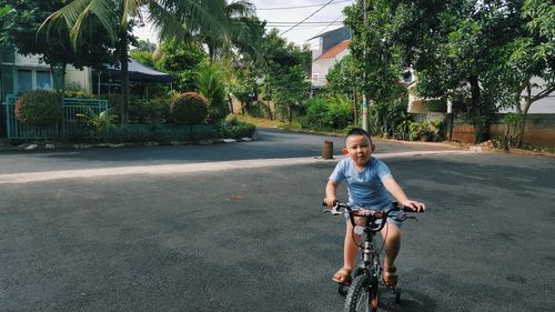 Portrait of boy riding bicycle on road