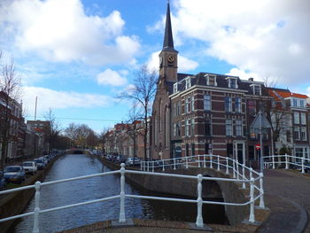 Canal amidst buildings against sky in city