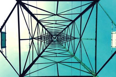 Low angle view of electricity pylon against blue sky