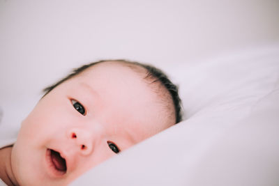 Portrait of cute baby lying on bed