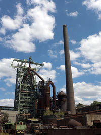 Low angle view of abandoned factory against sky