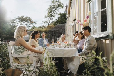 Male and female friends talking to each other during dinner party at cafe