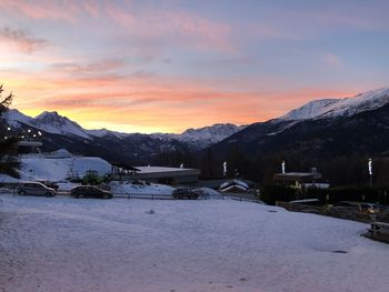 Scenic view of snowcapped mountains against sky during sunset