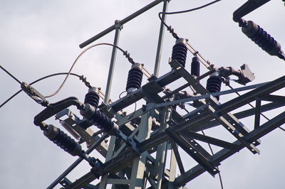 Low angle view of people working on bridge against sky