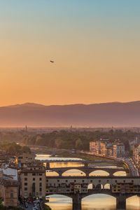 Sunset view of florence in italy with a passenger plane lifting