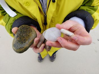 Midsection of man holding pebble stones