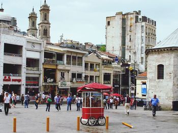 People on street against buildings in city