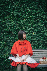 Full length of young woman standing against plants