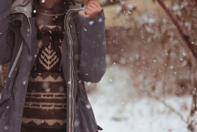 Midsection of woman in snow during rainy season