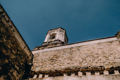 Low angle view of old building against clear blue sky