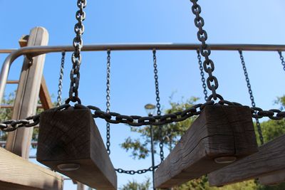 Low angle view of chain hanging against sky