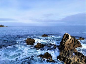 Rocks on sea shore against sky