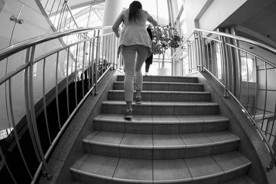 Rear view of woman moving up on staircase