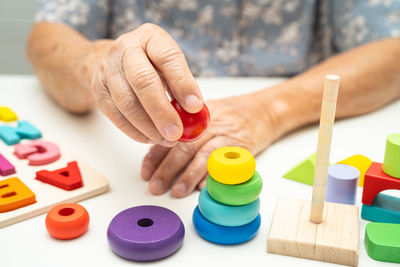 Cropped hand of person playing with toy blocks