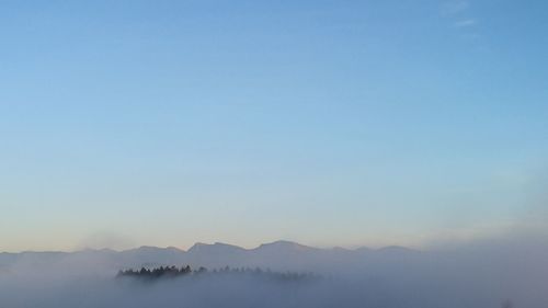 Scenic view of mountains against clear blue sky during sunset