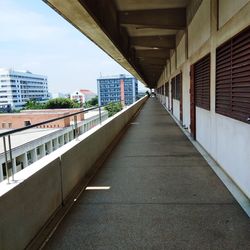 Empty walkway leading towards buildings in city