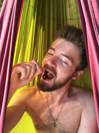 Portrait of young shirtless man with eyes closed