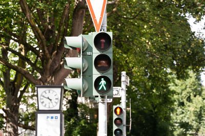 Low angle view of road signals against trees