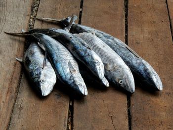 High angle view of fish on wooden table for sale in market