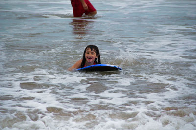 Portrait of smiling girl on surfboard