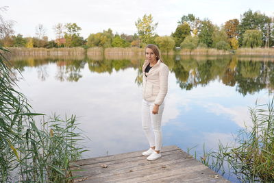 Woman standing by lake against sky