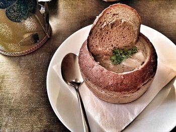 High angle view of potato soup served in bread on table