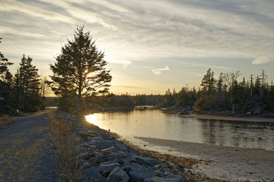 Scenic view of river against sky at sunset