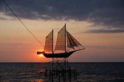 Silhouette sailboat on sea against sky during sunset