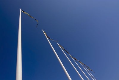 Low angle view of crane against clear blue sky