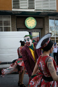 Full length portrait of happy woman standing against wall