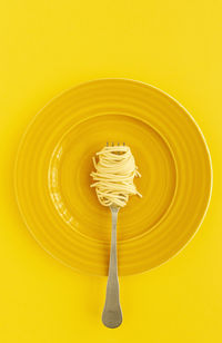 Close-up of fresh white wine on table against yellow background