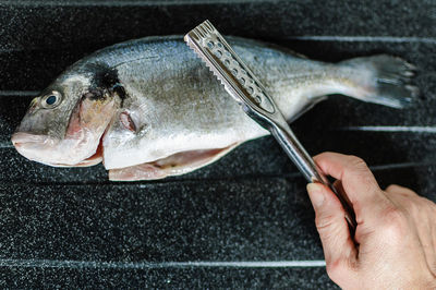 Close-up of hand preparing fish