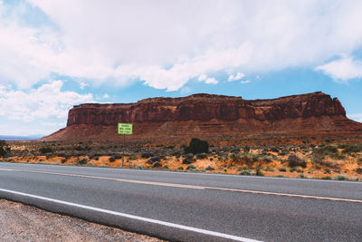Road by rock formation against sky