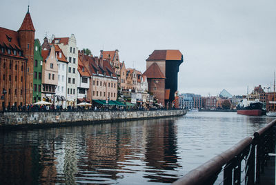 River by buildings in town against sky