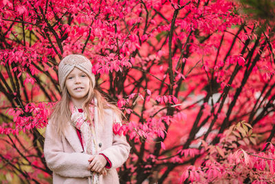 Portrait of a smiling young woman with pink cherry blossom