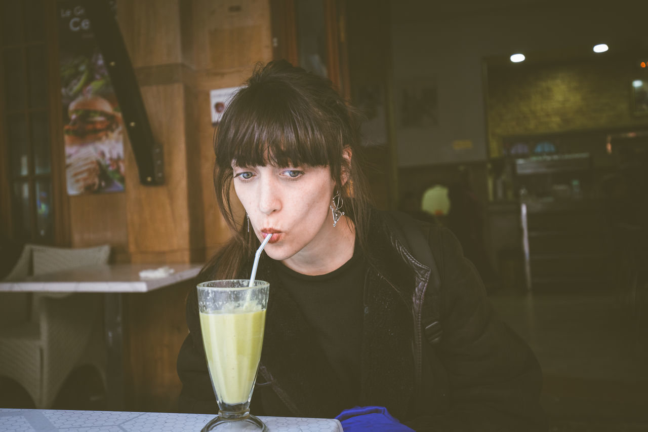 Portrait of young woman drinking smoothie