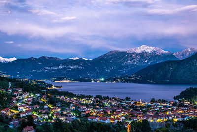 The lake como photographed from colonno, showing mountains, bellagio, and the town of colonno.