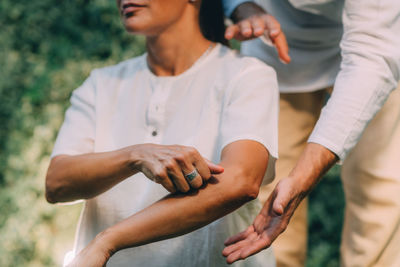 Reiki class. reiki instructor therapist holding hands over the elbow of a patient