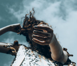 Close-up of woman hand by sea against blurred background