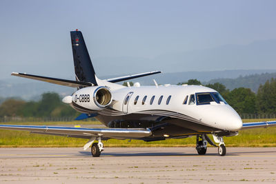 Airplane on airport runway against sky