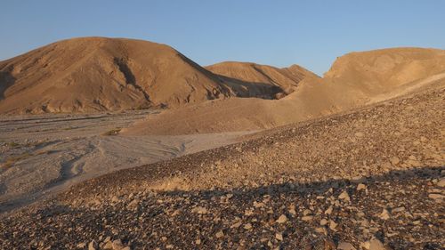 Scenic view of arid desert against sky at sunrise 