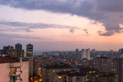 Illuminated cityscape against sky at dusk