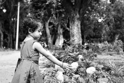 Boy looking at camera while standing by tree