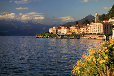 Scenic view of lake by houses against sky