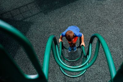 High angle view of boy playing on outdoor play equipment